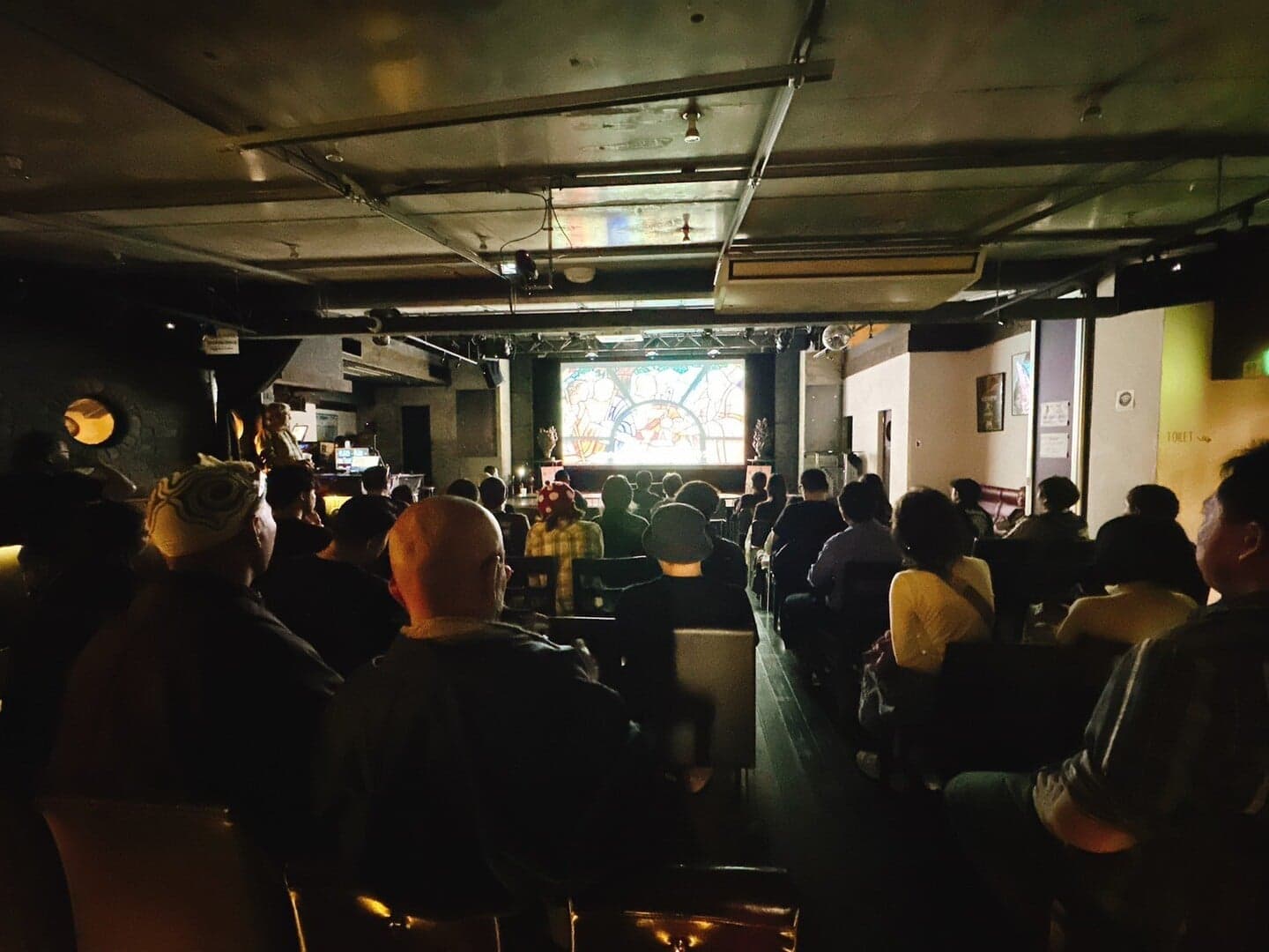 The audience watching a film on screen in a darkened auditorium